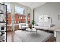 Bright living room boasts large windows with city views, light gray sofa set, and stylish decor at 720 16Th St # 306, Denver, CO 80202