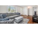 Comfortable living room featuring a plush gray sectional sofa, hardwood floors, and natural light at 2235 W 46Th Ave, Denver, CO 80211
