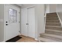 Inviting entryway featuring a decorative glass front door, coat closet, and carpeted stairs at 8652 Aberdeen Cir, Highlands Ranch, CO 80130