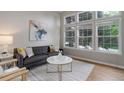Sunlit living room with large windows, grey sofa, white chairs and stylish decor at 8652 Aberdeen Cir, Highlands Ranch, CO 80130