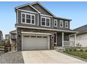 Charming two-story home featuring a gray exterior, white trim, a two-car garage, and a cozy front porch at 1373 E Witherspoon Dr, Elizabeth, CO 80107