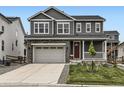Charming two-story home featuring a gray exterior, stone accents, a two-car garage, and a cozy front porch at 1373 E Witherspoon Dr, Elizabeth, CO 80107