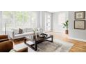 Bright living room with a large window, modern furniture, and light wood floors at 1541 Glencoe St, Denver, CO 80220