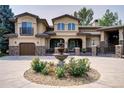 Stucco house exterior with stone accents, covered entryway, and a water fountain at 6783 E Orchard Rd, Greenwood Village, CO 80111