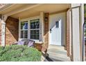 Inviting front porch with brick accents, a cozy bench, and a white front door at 18273 E Arizona Ave # D, Aurora, CO 80017