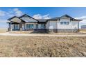 Beautiful ranch style home featuring white siding, dark trim, stone accents, and a covered front porch at 5424 Freddys Trl, Parker, CO 80134