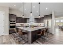 Modern kitchen with stainless appliances, a large island with seating, and stylish pendant lighting at 5424 Freddys Trl, Parker, CO 80134