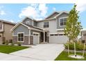 Beautiful two-story home with stone accents, gray siding, well-manicured lawn, and an attached three car garage at 6263 E 142Nd Pl, Thornton, CO 80602
