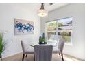 Bright dining area with a glass table, chairs, stylish lighting, and a large window at 8200 E 8Th Ave # 8101, Denver, CO 80230