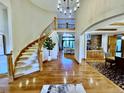 Grand foyer boasts a curved staircase, high ceilings, and gleaming hardwood floors at 5722 S Benton Way, Littleton, CO 80123