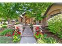 Charming front entrance with a brick walkway, manicured landscaping, and a beautiful wood door at 5722 S Benton Way, Littleton, CO 80123