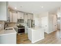 Modern kitchen featuring an island, stainless appliances, and light gray cabinets at 17881 East 94Th Ave, Commerce City, CO 80022
