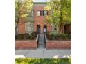 Beautiful brick townhome featuring classic design, landscaped yard, and steps to front door at 2958 N Xenia St, Denver, CO 80238