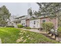 Exterior of townhomes featuring well-maintained lawns, brick accents, and inviting entrances at 5404 W Canyon Trl # C, Littleton, CO 80128