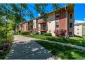 A view of the apartment building showcasing balconies, landscaping, and an inviting walkway at 12156 Melody Dr # 201, Westminster, CO 80234