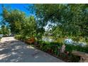 Scenic pond view from the apartment walkway, complete with benches, flowers, and greenery at 12156 Melody Dr # 201, Westminster, CO 80234