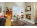 Inviting living room with lots of natural light from large windows, a brick fireplace, and comfortable seating at 1578 S Syracuse St, Denver, CO 80231