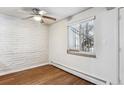 Bright dining area with white brick accent wall and hardwood floors at 875 S Quebec St # 24, Denver, CO 80247