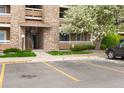 View of the condo's entrance highlighting the stone accents, landscaping, and convenient parking at 1074 S Dearborn St # 103, Aurora, CO 80012