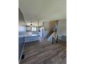 Open-concept living area featuring hardwood floors, a stylish gray accent wall, and seamless connection to the kitchen at 275 Mckinley Dr, Bennett, CO 80102