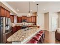 Open kitchen boasts a large island, granite countertops, dark wood cabinets and stainless steel appliances at 6916 Crestop Pl # F, Parker, CO 80138