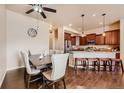 Open kitchen and dining area boasts hardwood floors, granite counters, and stainless appliances at 6916 Crestop Pl # F, Parker, CO 80138