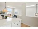 Open-concept layout with skylights providing ample natural light, complemented by modern decor and hardwood floors at 12050 Dahlia Dr, Thornton, CO 80241