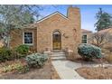 Inviting brick home with a distinctive arched front door, complemented by manicured bushes and stone accents at 1610 Locust St, Denver, CO 80220