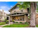 Attractive two-story home with brick facade, covered porch, and lush front yard at 562 N Gilpin St, Denver, CO 80218