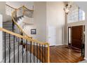 Grand entryway with a soaring ceiling, curved staircase, hardwood floors, and bright natural light at 10230 Knoll Ct, Highlands Ranch, CO 80130