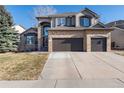Charming two-story home with a brick facade, arched entry, and a three-car garage at 10230 Knoll Ct, Highlands Ranch, CO 80130