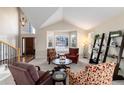 Inviting living room with vaulted ceilings, large windows, and cozy seating arrangement at 10230 Knoll Ct, Highlands Ranch, CO 80130