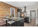 Modern kitchen with exposed brick, stainless steel appliances, and counter seating at 3321 Navajo St, Denver, CO 80211