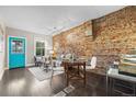 Living room featuring exposed brick wall, dark hardwood floors, and stylish modern furniture at 3321 Navajo St, Denver, CO 80211