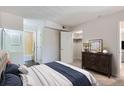 Comfortable bedroom featuring a plush bed, dark wood dresser and convenient access to the en-suite bathroom and closet at 3550 S Harlan St # 177, Denver, CO 80235