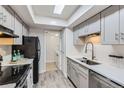 Well-appointed kitchen with gray cabinetry, stainless steel appliances, skylight and ample counter space for meal preparation at 3550 S Harlan St # 177, Denver, CO 80235
