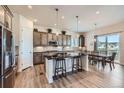 Modern kitchen features a large island with seating, stainless steel appliances, and elegant pendant lighting over the dining space at 4536 Shady Path Ln, Castle Rock, CO 80104