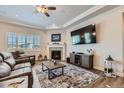 Cozy living room with fireplace, large TV, tray ceiling, and plush seating, creating a relaxing atmosphere at 4536 Shady Path Ln, Castle Rock, CO 80104
