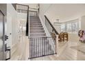 Inviting foyer with light wood flooring, modern black railings, and abundant natural light from large windows at 6550 S Oak Ct, Littleton, CO 80127