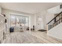 Bright living area features wood floors, a large window, and a modern staircase, creating a welcoming space at 6550 S Oak Ct, Littleton, CO 80127