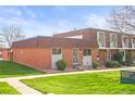 A low brick-exterior home with a manicured lawn and lovely landscaping at 770 S Youngfield, Lakewood, CO 80228