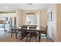 This dining room features a dark wood table, elegant lighting, and views of the kitchen at 5354 Blue Lunar Ln, Castle Rock, CO 80104