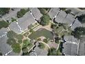 Aerial view showcases condo community with a scenic pond, trees, and walkways at 8600 E Alameda Ave # 17-203, Denver, CO 80247