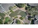 Drone image shows a community with pond, mature trees, and walking paths at 8600 E Alameda Ave # 17-203, Denver, CO 80247