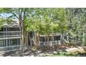 Exterior view of condo building featuring balconies, trees, and greenery at 8600 E Alameda Ave # 17-203, Denver, CO 80247
