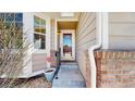 Inviting front entryway of home with charming brick accents and stylish storm door at 1229 Berganot Trl, Castle Pines, CO 80108