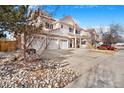 Attractive two-story home featuring stone accents, a three-car garage, and professional landscaping at 11885 Helena St, Commerce City, CO 80022
