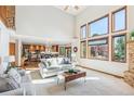 Bright living room featuring soaring ceilings, large windows, and an open layout connecting to the kitchen at 942 Xenon Ct, Golden, CO 80401