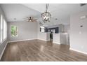 Bright, open-concept living room with hardwood floors, ceiling fan, and an adjacent kitchen area at 19663 E Mann Creek Dr # D, Parker, CO 80134