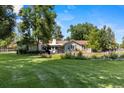 Beautiful backyard with lush green grass and mature trees providing shade and privacy for outdoor relaxation at 7750 W 5Th Ave, Lakewood, CO 80226